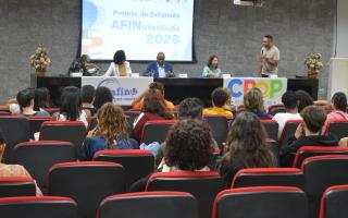 Imagem com os alunos do projeto Afin sentados observando a apresentação do professor Muriell Francisco da Costa, coordenador do projeto, que está ao lado de gestores da UFU