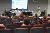 Imagem com os alunos do projeto Afin sentados observando a apresentação do professor Muriell Francisco da Costa, coordenador do projeto, que está ao lado de gestores da UFU